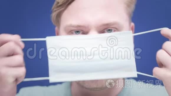 一个年轻人把医疗面具戴在脸上的肖像。 健康和安全生命概念，N1H1冠状病毒，病毒