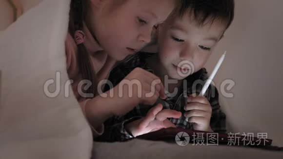 儿童躺在床上使用平板电脑视频