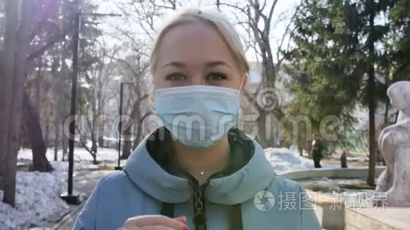 年轻的金发欧洲女人戴着医疗保护面具在城里。 疾病保护，冠状病毒，病毒性疾病