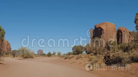在沙漠中的沙漠中，在红岩中驾驶尘土飞扬的泥土路