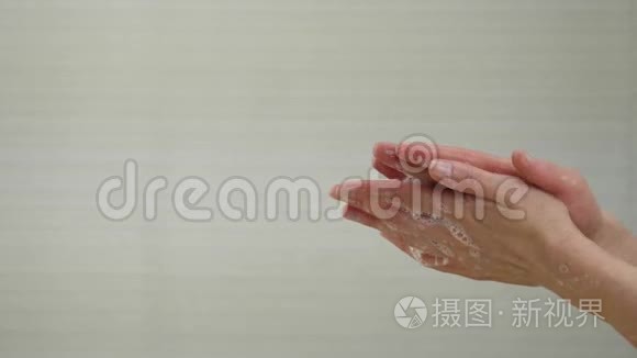 一个女人在特写镜头中用白色肥皂泡洗手。 示范洗手以防病毒