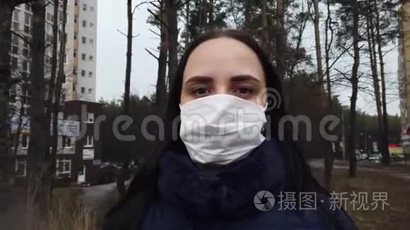 街上院子里戴着医用口罩的年轻女子的肖像。 成年女性用面具遮住她的脸