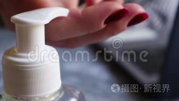 具有选择性聚焦的瓶子喷口上的特写图像。 女性手提供一剂防腐剂。 从细菌中洗手