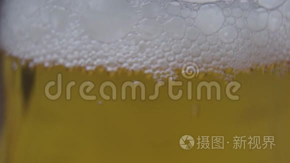 玻璃杯里的泡沫啤酒。 相机从泡沫向下移动到底部。 酿造，饮料，酒精