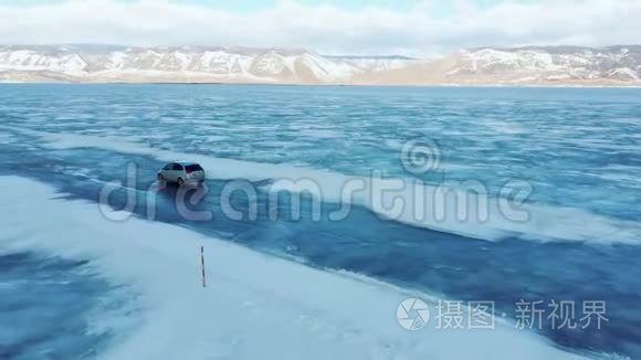 冬天，汽车在贝加尔湖的蓝色冰层上行驶。 四翼飞机侧面的跟踪视图