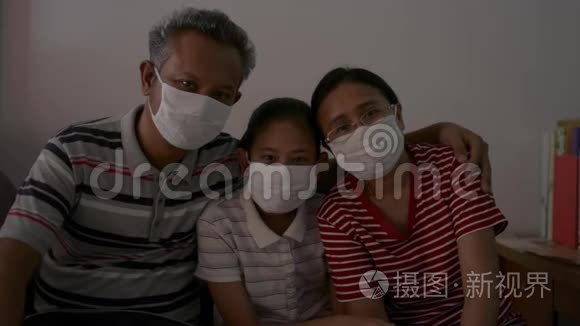 一个亚洲家庭在检疫中戴防护面罩以防止冠状病毒的肖像。