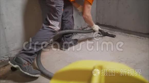 使用吸尘器的工人清除建筑碎片。 一名工人正在打扫工业场所。 公寓