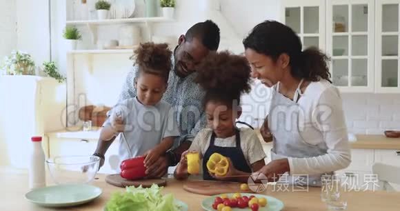 快乐的非洲父母教孩子们切沙拉烹饪厨房