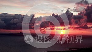 4K. 美丽的风景日落太阳穿过火红的天空背景。 无人机