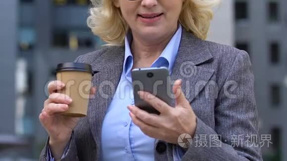 一位兴奋的女商人在喝咖啡的时候用手机说