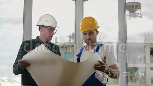 工程师和建筑工人讨论一份蓝图。