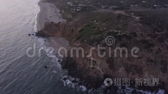 飞机从加州马里布岛上空飞行，日落时可看到海滩岸线和山崖