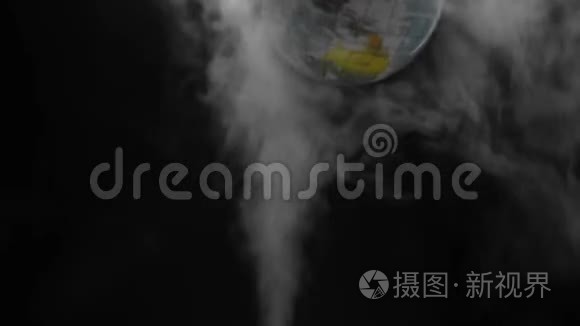 模拟的地球旋转在蒸汽烟雾之上，在黑色背景上爆炸。 被污染破坏的地球概念..