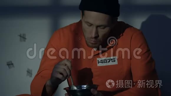 饥饿的白种人囚犯在牢房里吃饭，可怕的恶心食物，条件