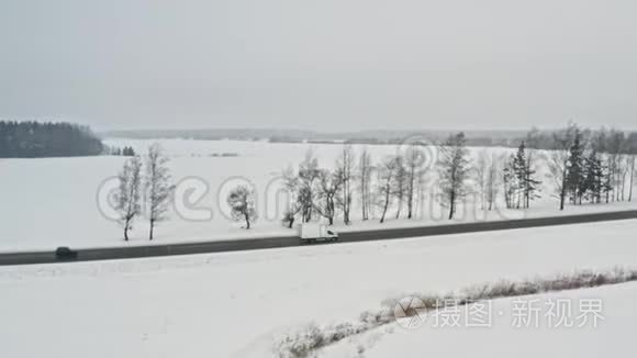 送货车在冬季乡村道路上行驶，从在4k的空中俯瞰。 跟踪射击。 把所有东西都送到任何地方