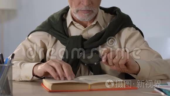 老年人通过放大镜阅读书籍，老年视力障碍