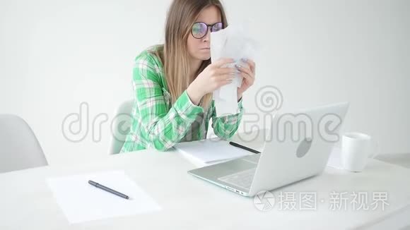 妇女通过将信息输入笔记本电脑来考虑购买和支付信贷的费用数额。