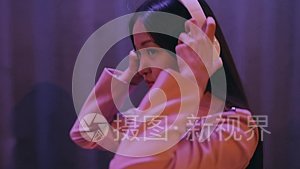 亚洲女人在城市的夜晚戴上耳机走路