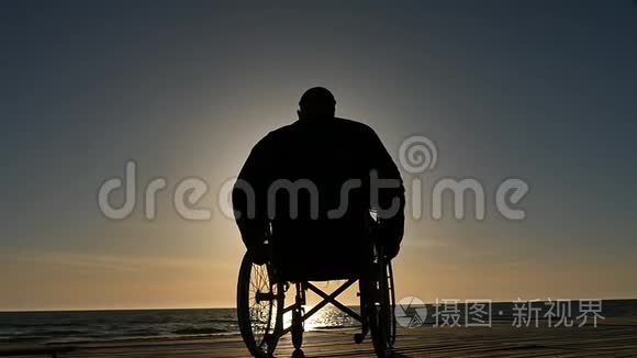 坐轮椅的人靠近海平面视频
