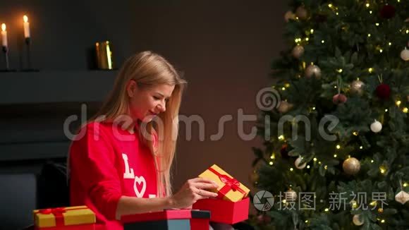带着圣诞帽的女孩许愿并打开圣诞礼物包。节日和新年的概念。