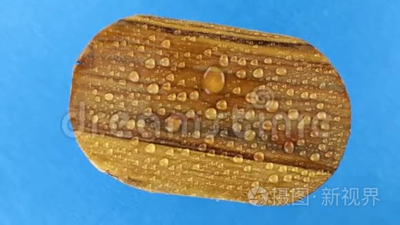 俯视图,旋转一个旧木卵圆板在雨滴. 孤立短视频