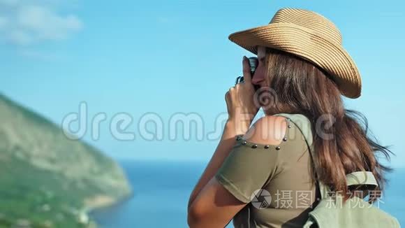 女摄影师在日落时用专业的老式摄像机拍摄海景