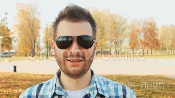 戴墨镜和衬衫的满脸胡须的微笑男人的肖像