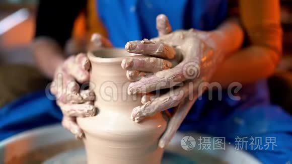 一对夫妇的手在陶工的轮子上打碎了陶罐。 有趣，快乐，快乐的约会。 浪漫中人们的性感镜头