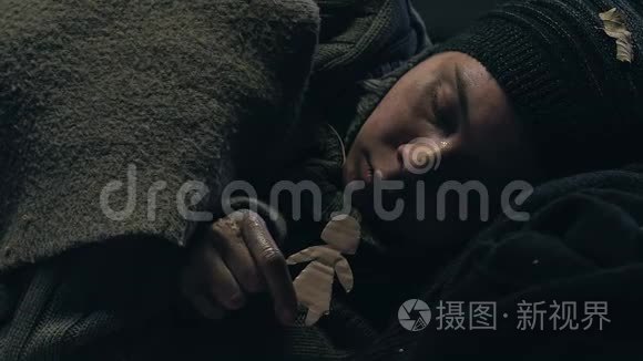 无家可归的少年抱着小纸男，难民梦想着家庭和家