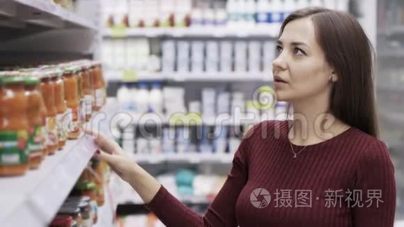 美丽的女孩选择商店里的食品视频