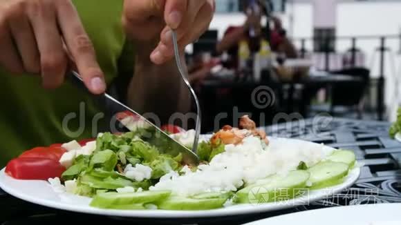 男人切鸡串特写，用沙拉把烤串串在叉子上