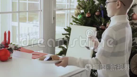 男孩带着饼干和牛奶开始写信给圣诞老人