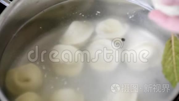 在沸水中煮饺子或馄饨，逐渐放入沸水中