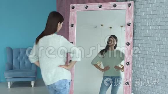 优雅的女人在家里对着镜子摆姿势