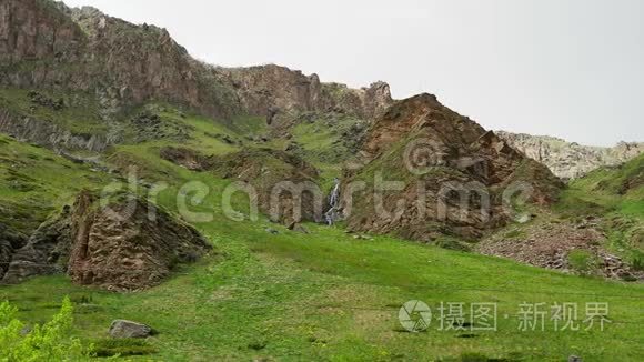 美丽的风景，可以看到多石山、小瀑布和长满绿草和绿草的山脉