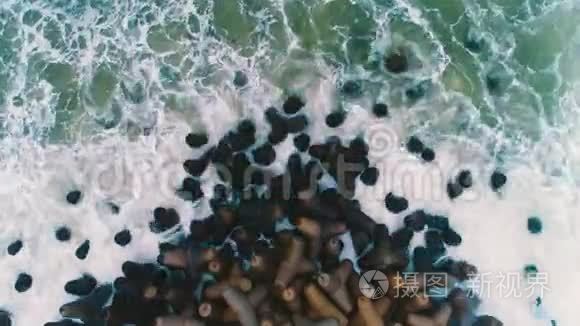 海波撞击海滩岩石的高空俯视图视频