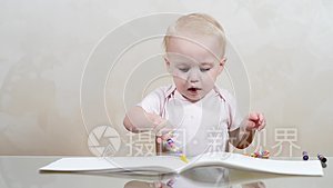 孩子在相册里画涂鸦，然后拿蜡笔和快乐的树叶