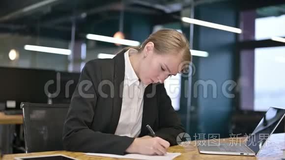 年轻的女商人试图在办公室写文件