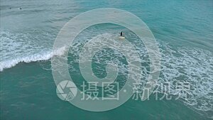 从上面的运动青年男女冲浪，乘坐大浪与明亮的日光，冲浪者正在等待他